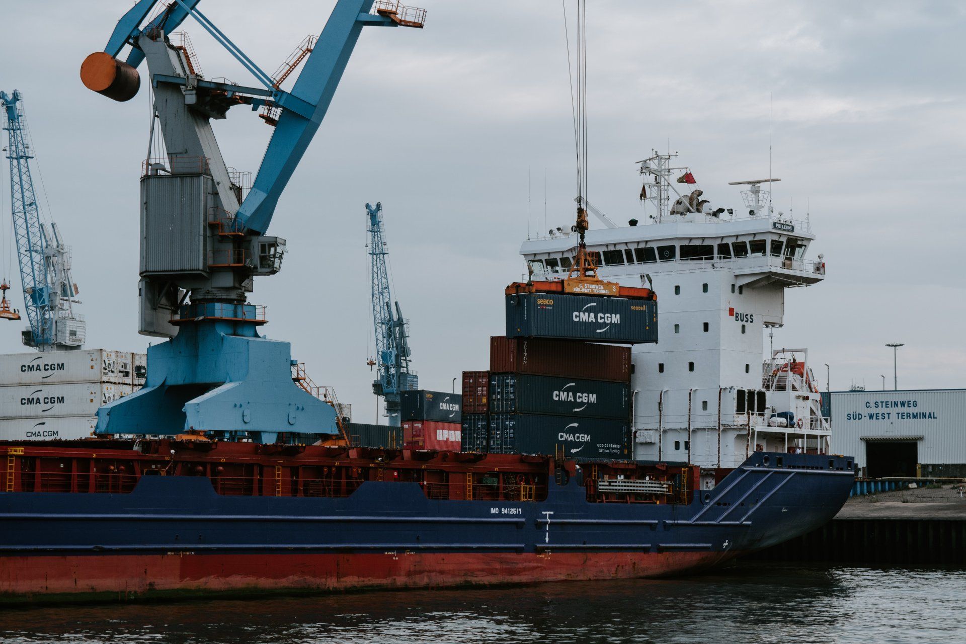 Un grand cargo est amarré dans un port avec des grues.